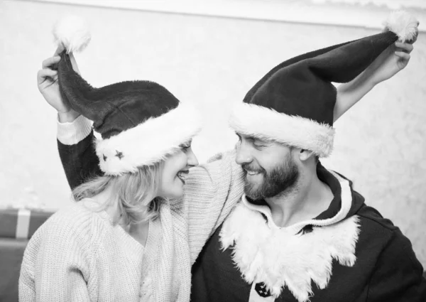 Par i kärlek njuta av julfirande. Par bär hattar som jultomten julgran bakgrund. Det är lätt att sprida glädje runt. Lycklig familj firar jul. Jul kul koncept — Stockfoto