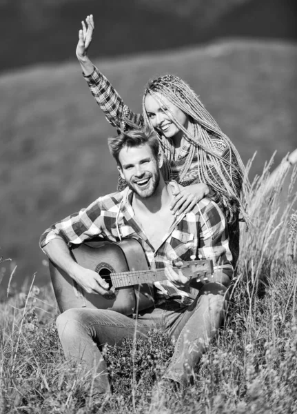 Honeymoon trip. couple in love spend free time together. happy friends with guitar. country music. romantic date. friendship. campfire songs. men play guitar for girl. western camping. hiking