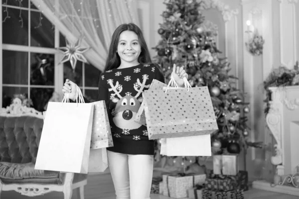子供女の子クリスマス プレゼントのような。明けましておめでとう。クリスマスに小さな幸せな女の子。クリスマス。子供では、休暇をお楽しみください。クリスマス前に朝。年末年始。買い物袋を持つ少女。クリスマスのごちそう — ストック写真