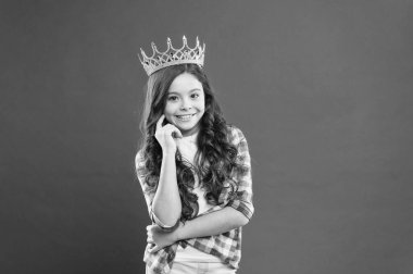 Gurur kaynağı. Gururlu küçük kız kırmızı arka plan üzerinde gururla taç mücevher giyiyor. Uzun kıvırcık saçlı sevimli küçük çocuk büyük gurur hissi. Gurur kavramı