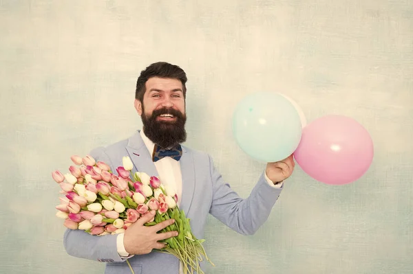 花の配達。紳士のロマンチックな日付。誕生日のご挨拶。特別な誰かが。男性ヒゲ紳士スーツ蝶ネクタイは、気球と花束を保持します。彼女のためのロマンチックな驚きを作る紳士 — ストック写真
