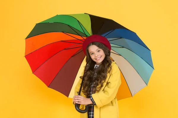 Beste mode keuze. Gelukkig kind met mode regen accessoire op gele achtergrond. Klein meisje houden regenboog gekleurde mode paraplu. Herfst look van kleine mode model. Terug naar school — Stockfoto