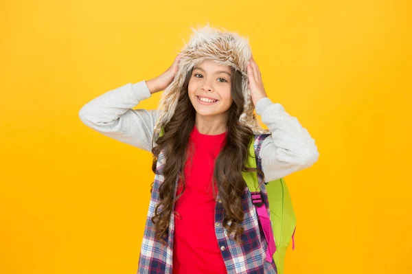 Moda e beleza. Menina feliz em chapéu de moda de pele no fundo amarelo. Olhar de inverno de modelo de moda pequeno. Moda de tempo gelada de crianças. Adorável e bonito — Fotografia de Stock