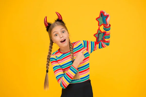 Ik bereid me voor op het feest. Start dit feest. Feestattributen. Speels demonenmeisje. Klein kind met rode hoorns en brillen. Accessoires voor carnaval. Meisjeshumeur. Leuk maar gevaarlijk. Halloween concept — Stockfoto