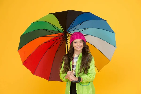 Umbrella cant stop rain. Happy small child in raincoat carry umbrella against rain. Cute little schoolgirl hide under umbrella on wet rain weather. It makes her to stand in rain