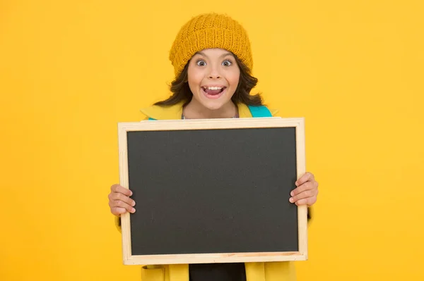 Matériel éducatif d'information. Heureux petit enfant tenir tableau blanc pour l'éducation sur fond jaune. Enseignement primaire obligatoire. Programme d'éducation publique, espace de copie — Photo