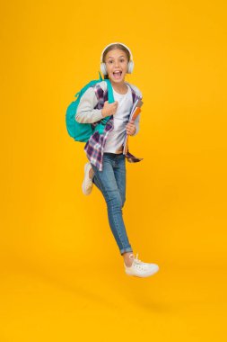 Okul günlük hayatı. Mutlu tasasız çocuk. Okul ve boş zaman. Modern eğitim. Enerjik neşeli genç müzik dinliyor. Şık liseli kız okula gidiyor. Modaya uygun küçük kız sırt çantası taşıyor.