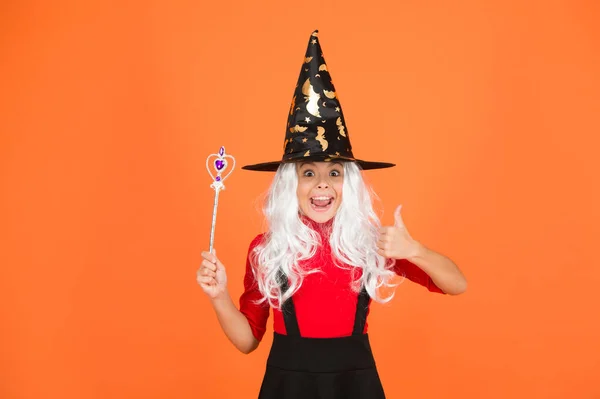 Divertirse con la magia. Niña con disfraz de bruja. Fiesta de Halloween. Niña con sombrero de bruja negro. Vacaciones de otoño. Únete a celebración. Conjuro mágico. Pequeña bruja de pelo blanco. Asistente con palo — Foto de Stock