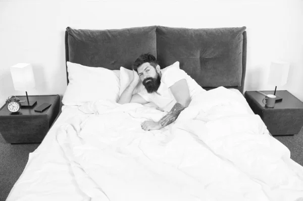 失眠。睡眠障碍的概念。留胡子的嬉皮士睡眠有问题。躺在床上的家伙试图放松和入睡。放松技术。睡眠和清醒的侵犯 — 图库照片