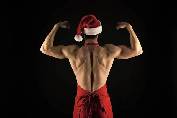 Sporcu adam santa şapka giymek. Seksi atletik maço geri santa claus şapka kas. Yakışıklı Noel kavramı. Maço kas gövde güvenle poz. Noel Baba yetişkin kızlar için. Güçlü bir çekici adam — Stok fotoğraf