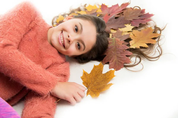 A gyerekek szeretik az őszi szezont. Lány aranyos gyerek hosszú haj feküdt fehér háttér lehullott levelek. Száraz juharfalevél frizurában. Őszi szezon koncepció. Hajápolás ősszel. A száraz hasított szőrszálak megakadályozása — Stock Fotó