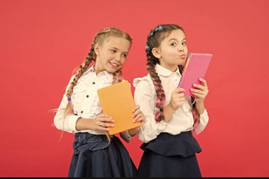 Her gün oku. Sevimli küçük çocuklar kırmızı arka plan okumak için kitap tutan. Sevimli küçük kızlar okulda okumayı öğreniyorlar. Farklı bir dünyaya girin, okuyun