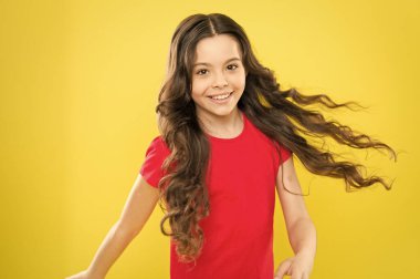 Moda güzeli. hippi çocuk. çocukluk mutluluğu. Uzun kıvırcık saçlı mutlu kız. Kuaför salonu. Cilt bakımı ve doğal saç. Küçük kız gülümsüyor. Rüzgarlı saçlar. Küçük manken. saç modası