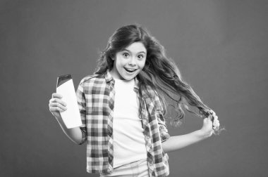 Kuru şampuan. Çocuklar için saç stili yapmak için kolay ipuçları. Güçlü ve sağlıklı saç konsepti. Uzun süreli tazelik. Tazele. Küçük çocuk uzun saçlı. Uzun saçlı aktif bir kız. Şampuan şişesi.