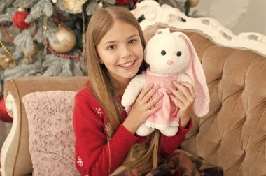 Onun çok sevimli. Yumuşak oyuncak ile küçük çocuk oyun. Küçük çocuk mevcut ile gülümseyen mutlu. En iyi Noel oyuncak. Noel ağacı, sevimli tavşan ile küçük kız. Küçük kız tavşan oyuncak tutun