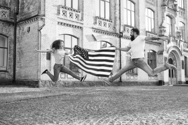 Utforska USA. Semester och resa. Självständighetsdagen. Nationell helgdag. Skäggiga hipster och flicka hoppning. 4 juli. Amerikansk tradition. Amerikanska patriotiska människor. Amerikanskt par USA flagga utomhus — Stockfoto