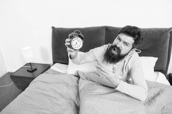 Get up early. Tips for waking up early. Man bearded hipster sleepy face waking up. Daily schedule for healthy lifestyle. Alarm clock ringing. Hate this noise. Problem with early morning awakening