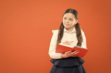 okuma dersi. Mutlu çocuk çalışma ve kitap okuma keyfini çıkarın. Okula geri dön. bilgi formu kitap almak. Okul dersinde küçük kız. turuncu arka plan üzerine notlar yazma kız öğrenci. kopya alanı. Ders.