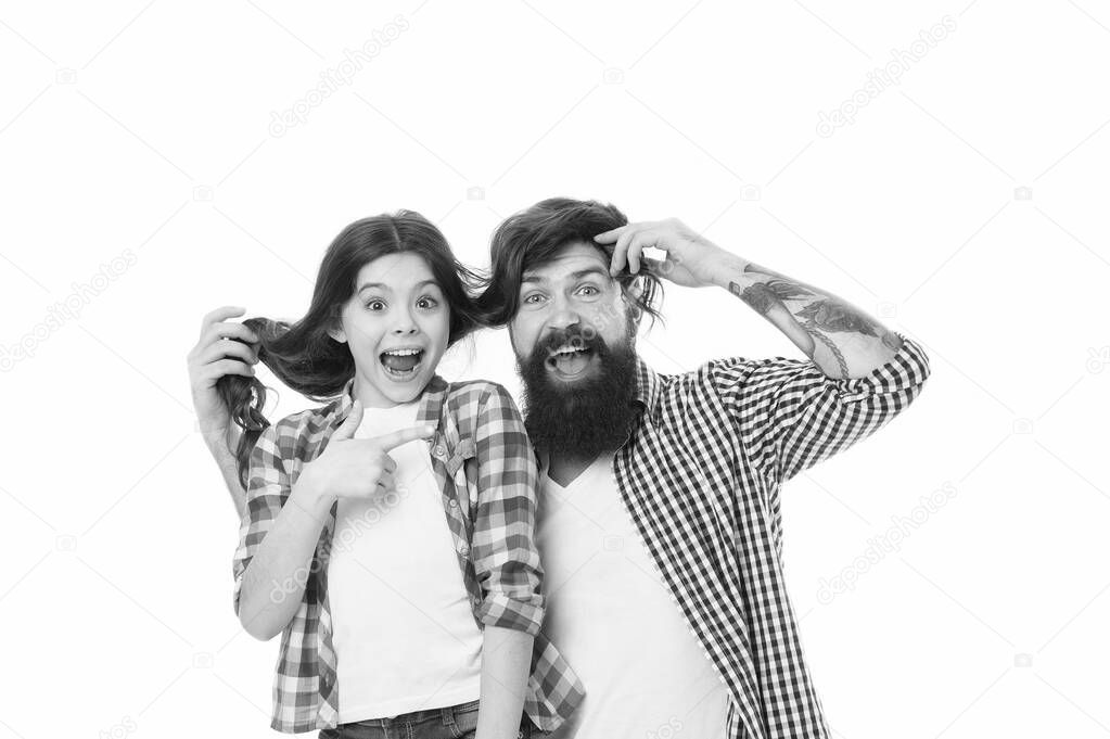 He envies my hairstyle. Man with beard and little girl long hair on white background. Father play with hair of kid. Hairdresser and barber concept. Having fun with long hairstyle. Hair care