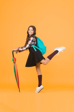 Yağmur koruması. Yağmura karşı şemsiyesi olan mutlu küçük çocuk. Şirin küçük okul kızı yağmurlu havalarda şemsiye kullanır. Sonbahar modası ve aksesuarı. Okul zamanı. Yağmurda durmasını sağlıyor.