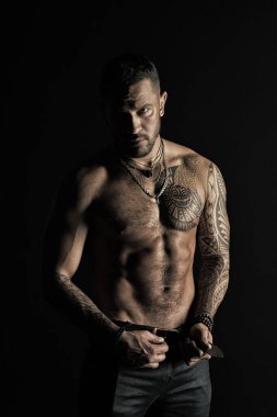 Sakallı adam gömleksiz fit vücut'la. Dövme tasarım cilt üzerinde olan adam. Kot pantolon moda model toka deri kemer. Sporcu altı paketi ve AB Fitness Spor ve welness, vintage filtre ile