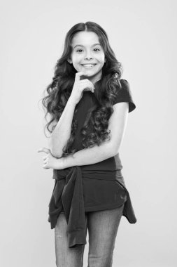 Uzun kıvırcık saçlı mutlu kız. çocukluk mutluluğu. Kuaför salonu. Cilt bakımı ve doğal saç. moda ve güzellik. hippi çocuk. Küçük kız gülümsüyor. Uzun kıvırcık saçlar mükemmel görünüyor. Esmer saçlı.