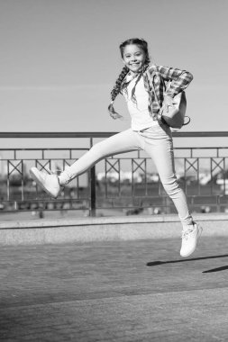 Dışarıda aktif olmak. Kentsel altyapıda hareketli küçük bir çocuk. Zevk için atlayan mutlu küçük kız. Aktif ve enerjik bir çocuk yazın eğleniyor.