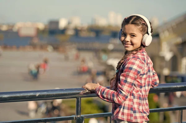 Music everywhere you go. Child listen music outdoors modern headphones. Kid little girl listen song headphones. Music account playlist. Customize your music. Urban child leisure. Small kid relaxing