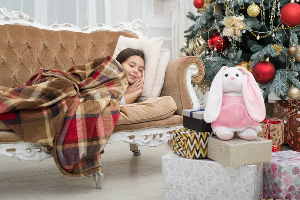 Uwierz w cuda. Magiczna chwila. Boże Narodzenie. Szczęśliwego Nowego Roku. Mała dziewczynka śpi kanapa w pobliżu choinki klasyczne wnętrze. Rodzinne wakacje. Choinka i prezenty. Śniłem o prezentach. — Zdjęcie stockowe