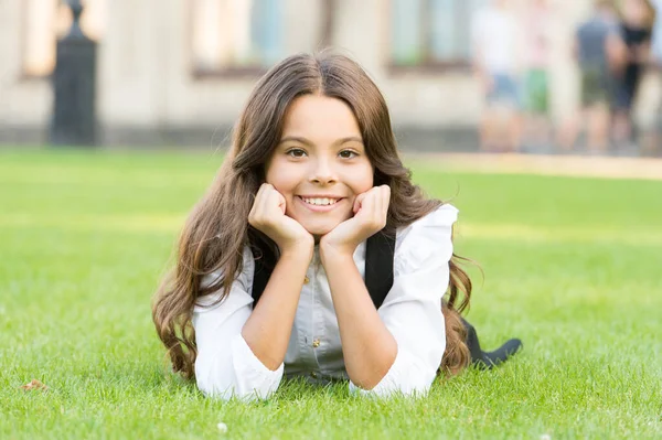 Snění o budoucnosti. Šťastná dívka odpočívat na zelené trávě. Malé dítě s roztomilým úsměvem. Budoucí generace. Budoucnost vzdělávání. Vzdělání dává znalosti a lepší budoucnost — Stock fotografie