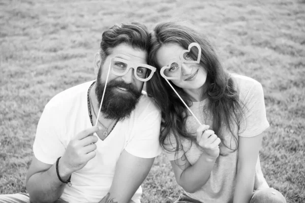 Emotional couple radiating happiness. Love story. Couple relaxing green lawn. Man bearded hipster and pretty woman in love. Summer vacation. Happy together. Couple in love cheerful youth booth props — Stock Photo, Image