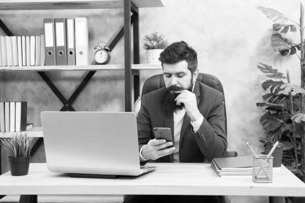 İşadamı resmi kıyafeti. Kendine güvenen adam dizüstü bilgisayar ve cep telefonu kullanın. Patron iş ile hareket eden telefon. Sakallı adam iş ofiste. Manifatura meslektaşım. Her zaman temas halinde. manifatura üstünde hareket eden telefon