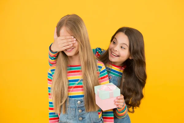 Adivina quién. Niña recibiendo un regalo sorpresa. Sorpresa de cumpleaños. Lindo niño pequeño hacer sorpresa a un amigo o hermana. Qué agradable sorpresa. Celebración festiva — Foto de Stock