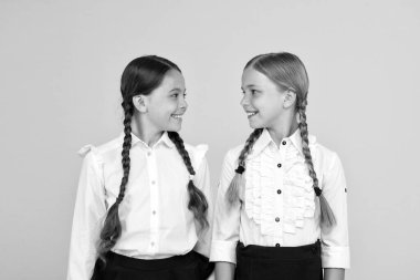 Çalışmayı seviyoruz. Üniformalı mutlu çocuklar. sarı arka planda küçük kızlar. dostluk ve kardeşlik. En iyi dostlar. çocuk resmi moda. Yurtdışında eğitim. akıllı görünümlü çocuklar. okul arkadaşları