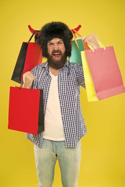 Alışveriş şampiyonu. Boğa boynuzları şapkalı mutlu hipster başarılı alışveriş sonrası paperbags Limited tutarak. Sakallı adam alışveriş çantaları ile gülümsüyor. Alışveriş onun bağımlılığı.