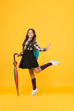 Mutlu ol ve okula git. Küçük çocuk sonbaharda okula geri dönüyor. Küçük kız okula sopa şemsiyesi ve sırt çantası taşıyor. Okul yağmurlu havada açıktır. Eğitim