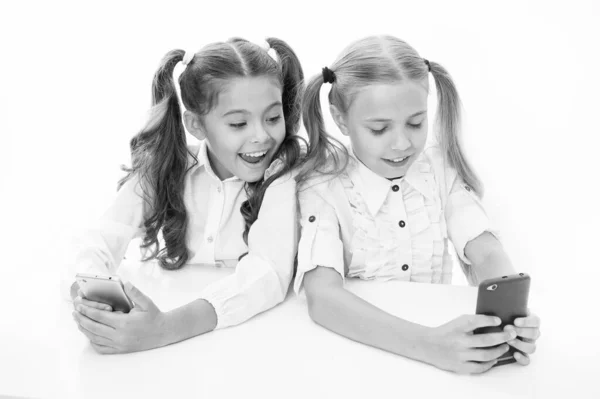 Blog voor studenten. Kleine kinderen typen nieuwe blogpost vanaf smartphone. Kleine bloggers houden klasse blog bij. Slimme meisjes posten hun blog op online sociaal netwerk via mobiel apparaat — Stockfoto