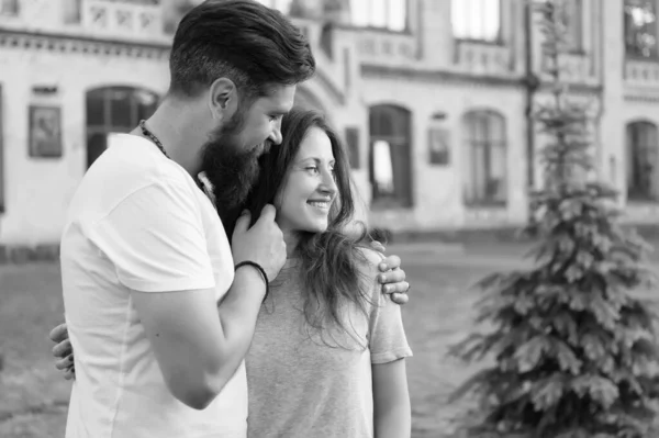 Couple relaxing enjoying each other. Hipster and pretty woman in love stand in street architecture building background. Feel my love. Happy together. Couple in love walking having fun. Tender hug