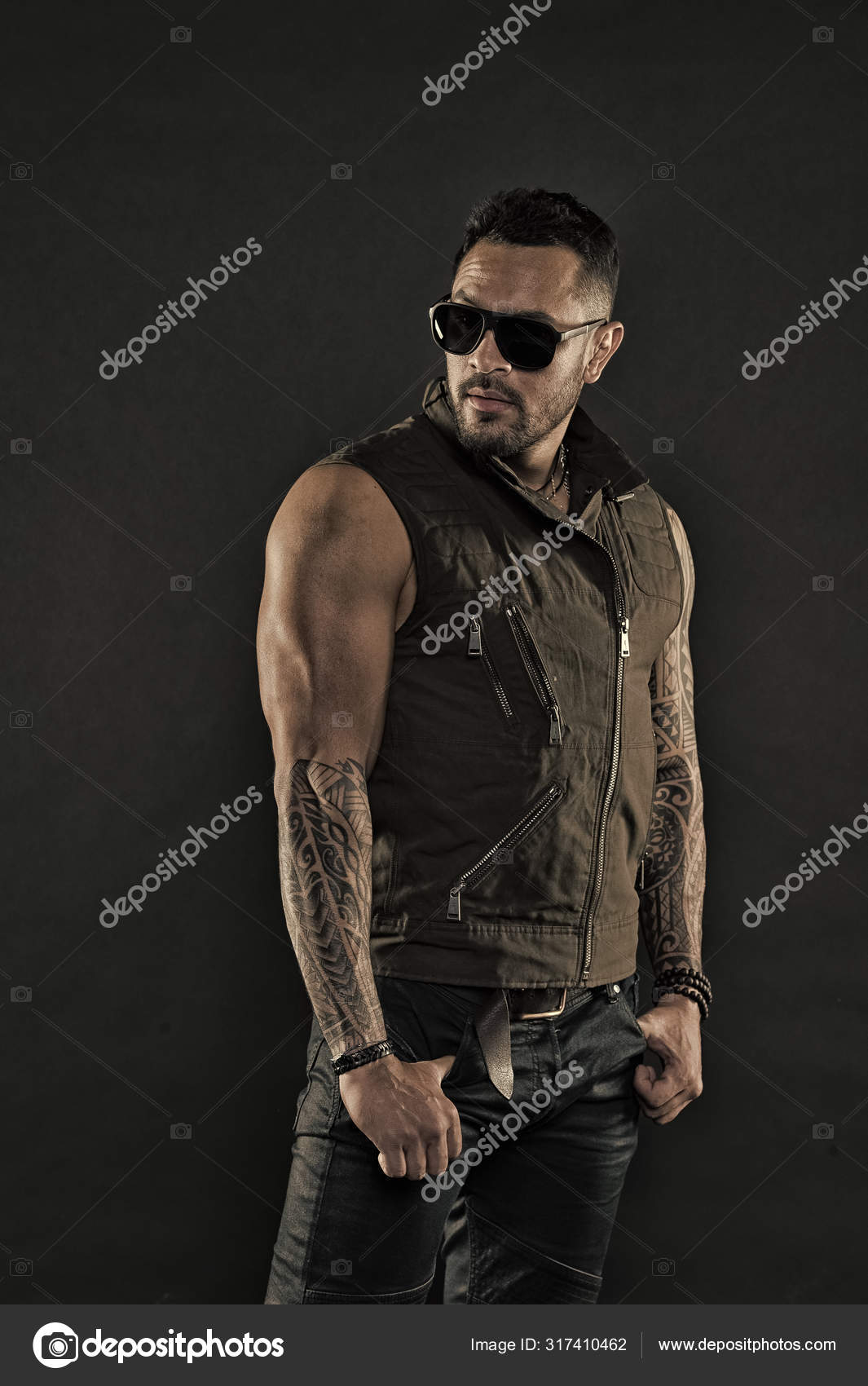 Tätowierter Mann mit Bizeps und Trizeps. Tätowiermodell mit Bart auf  unrasiertem Gesicht. bärtiger Mann mit Tätowierung auf starken Armen. Macho  in trendiger Sonnenbrille. Modestil und Trend – Stockfoto © stetsik  #317410462, image size:1065x1700