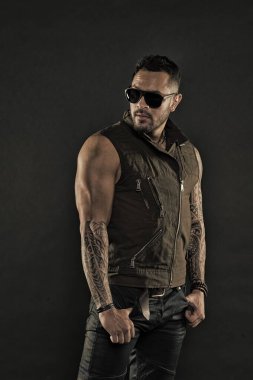 Pazı ve triceps dövmeli adam. Tıraşsız yüzündeki sakallı dövme modeli. Güçlü silah dövme sakallı adam. Moda maço trendy güneş gözlüğü. Moda stil ve eğilim