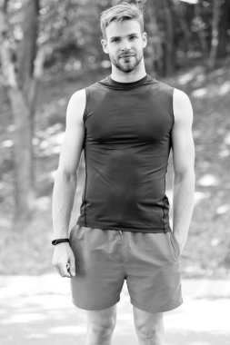 Sağlıklı ve kaslı. Yaz gününde kaslı adam eğitimi. Kaslı kolları olan atletik adam parkta çaprazlanmış. Yakışıklı sporcu veya kas gücü ve gücü ile atlet