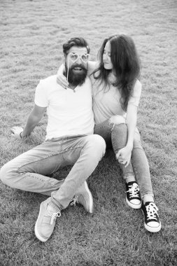 Aşık olmak. Sakallı adam kalp şeklindeki pervane gözlükleriyle sevgiyle bakıyor. Yeşil çimenler üzerinde dinlenen aşık şehvetli çift. Seksi kadın ve hipster bir aşk ilişkisi yaşıyor