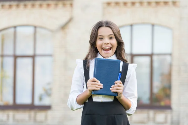 De bonne humeur. Bonne petite fille de retour à l'école. Petit enfant joyeux avec un sourire heureux de manière formelle. Adorable enfant avec regard heureux en plein air. À l'école. Éducation et connaissance — Photo