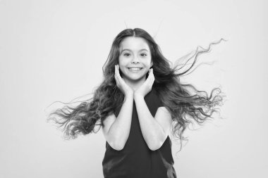 Gülümse, bedava terapi. Sarı arka planda büyük bir gülümsemesi olan sevimli küçük bir kız. Yüzünde beyaz, sağlıklı bir gülümseme olan gülümseyen çocuk. Uzun dalgalı saçları ve mutlu gülüşü olan sevimli küçük bir çocuk.