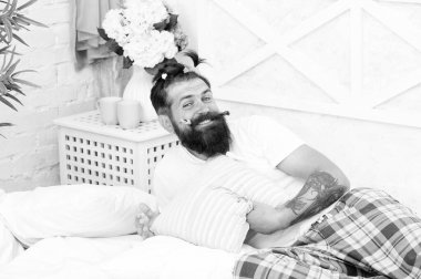Yine çocuksu. Çocuksu saç modeli renkli at kuyruğu ile Adam yetişkin sakallı yakışıklı hipster. Pijama partisi. Yatak odasında dinlenen adam. Pijama stili. Evde pijamalı bir adam. Eğlenceli pijama partisi