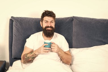 Rahatla ve dinlen. İnsanlık kahveyle çalışır. Adam acımasız yakışıklı hipster rahatlatıcı yatak odası içki kahve. Sakallı adam sabah kahvesi içiyor. Yeni güne uyum içinde. Sabah fincan kahve ile daha iyi uyanma