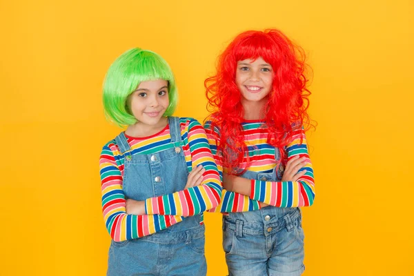 Casual, mas luxuoso. Olhar de festa casual de crianças pequenas. Meninas pequenas usam perucas de cabelo coloridas em estilo casual jeans. Crianças felizes vestidas para festa ou cosplay. Casual de vestir. Moda e moda — Fotografia de Stock