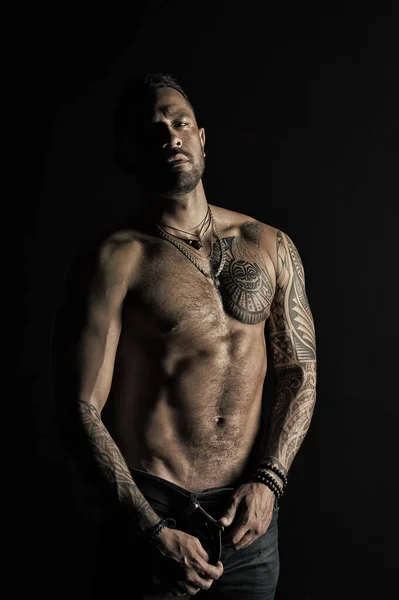 Sportsman with six pack and ab. Bearded man shirtless with fit torso. Man with tattoo design on skin. Fashion model buckle leather belt in jeans. Fitness with sport and bodycare, vintage filter — ストック写真