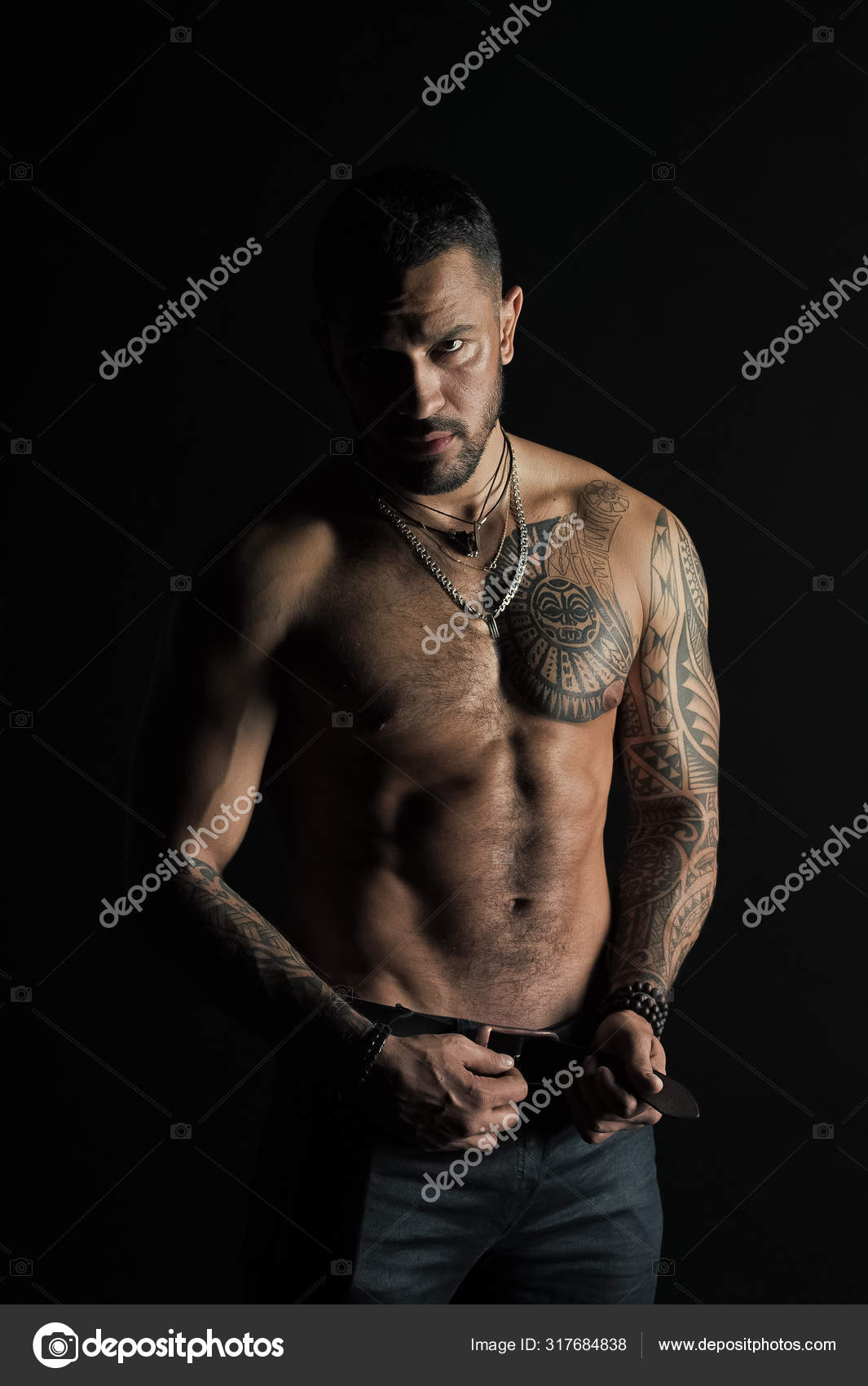 Fashion model buckle leather belt in jeans. Man with tattoo design on skin.  Bearded man shirtless with fit torso. Sportsman with six pack and ab.  Fitness with sport and bodycare Stock Photo