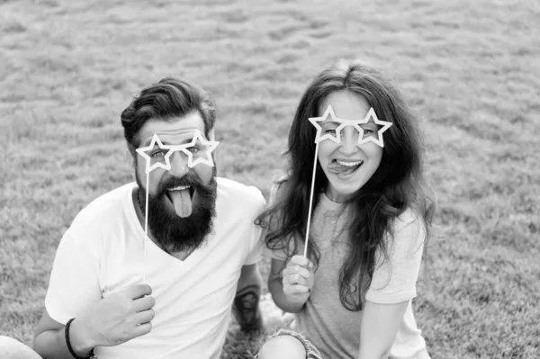 Youth day. Summer entertainment. Emotional people. Couple dating. Carefree couple having fun green lawn. Couple in love cheerful youth booth props. Man bearded hipster and pretty woman cheerful faces